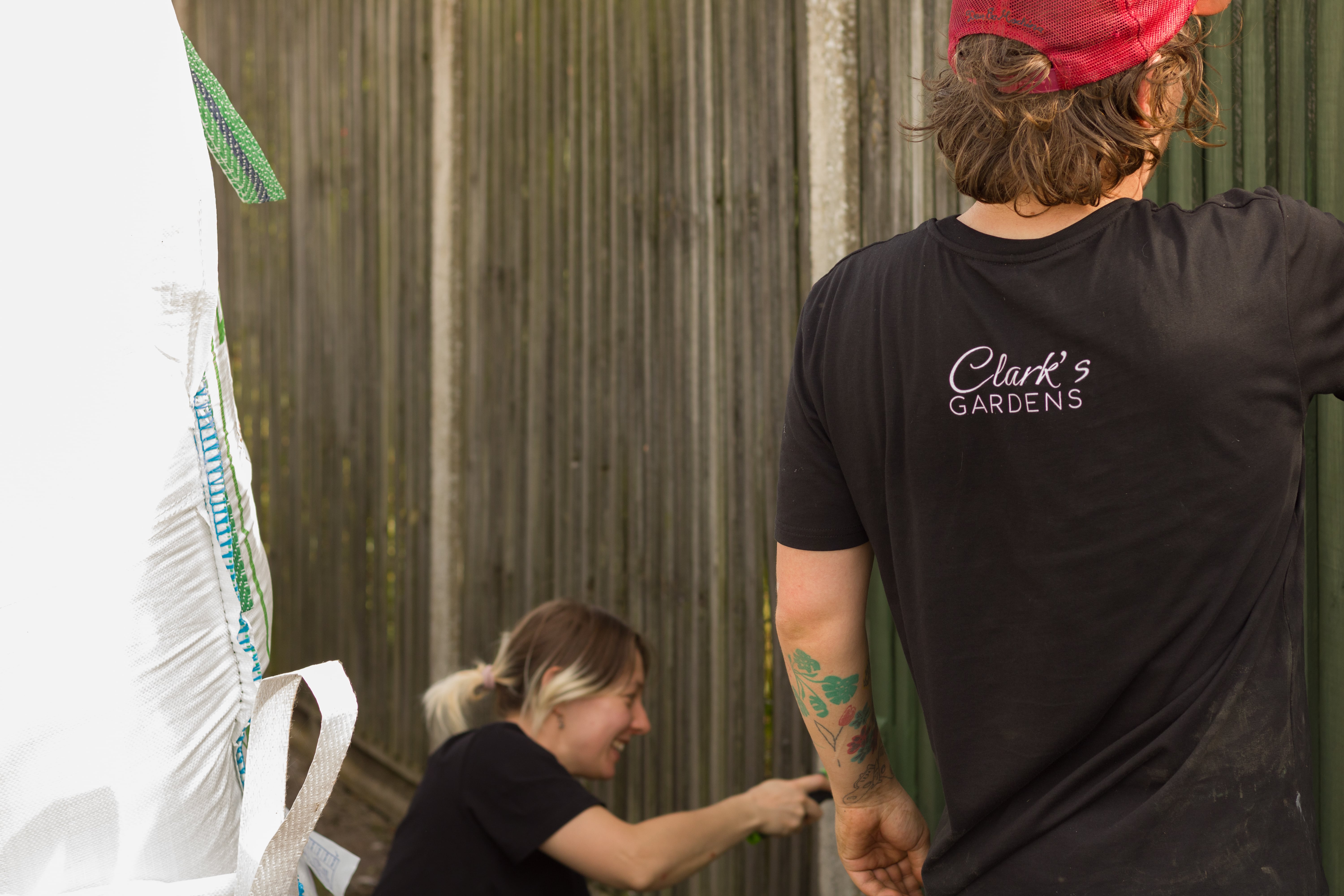 Photo of Clark's Gardens team painting fence